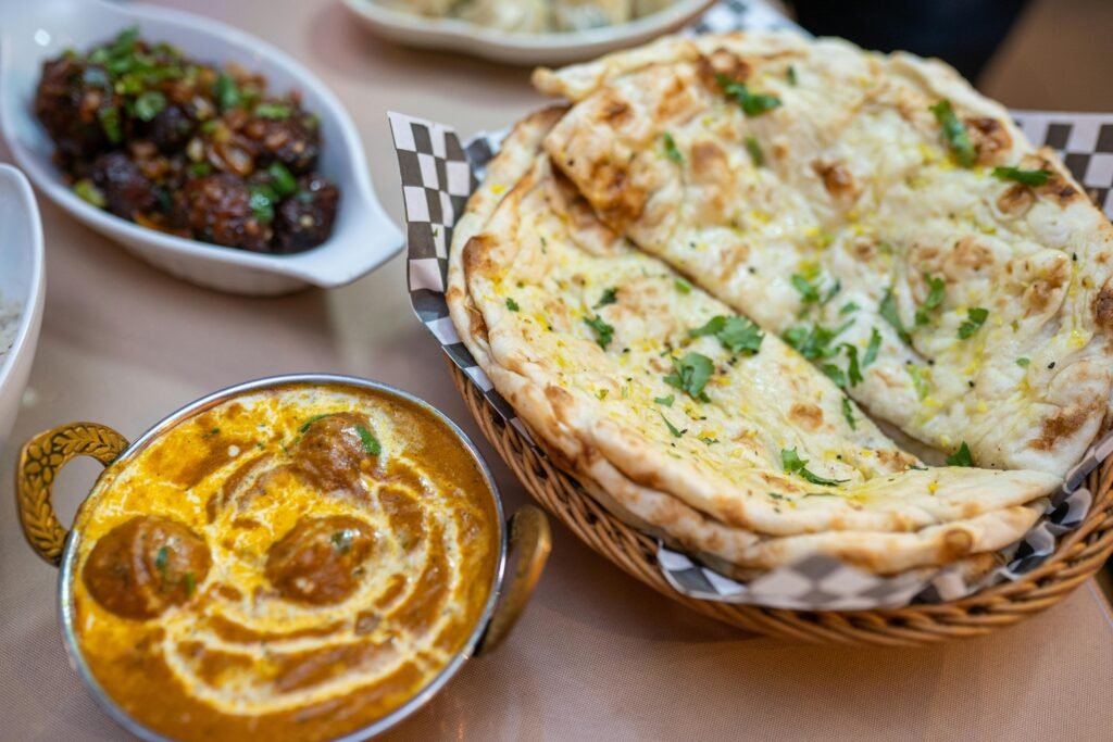 A delicious spread of Indian cuisine featuring curry, naan bread, and flavorful dishes.